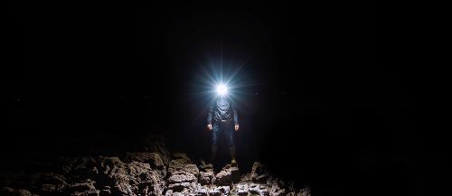 Randonneur de face avec une lampe frontale allume dans la nuit